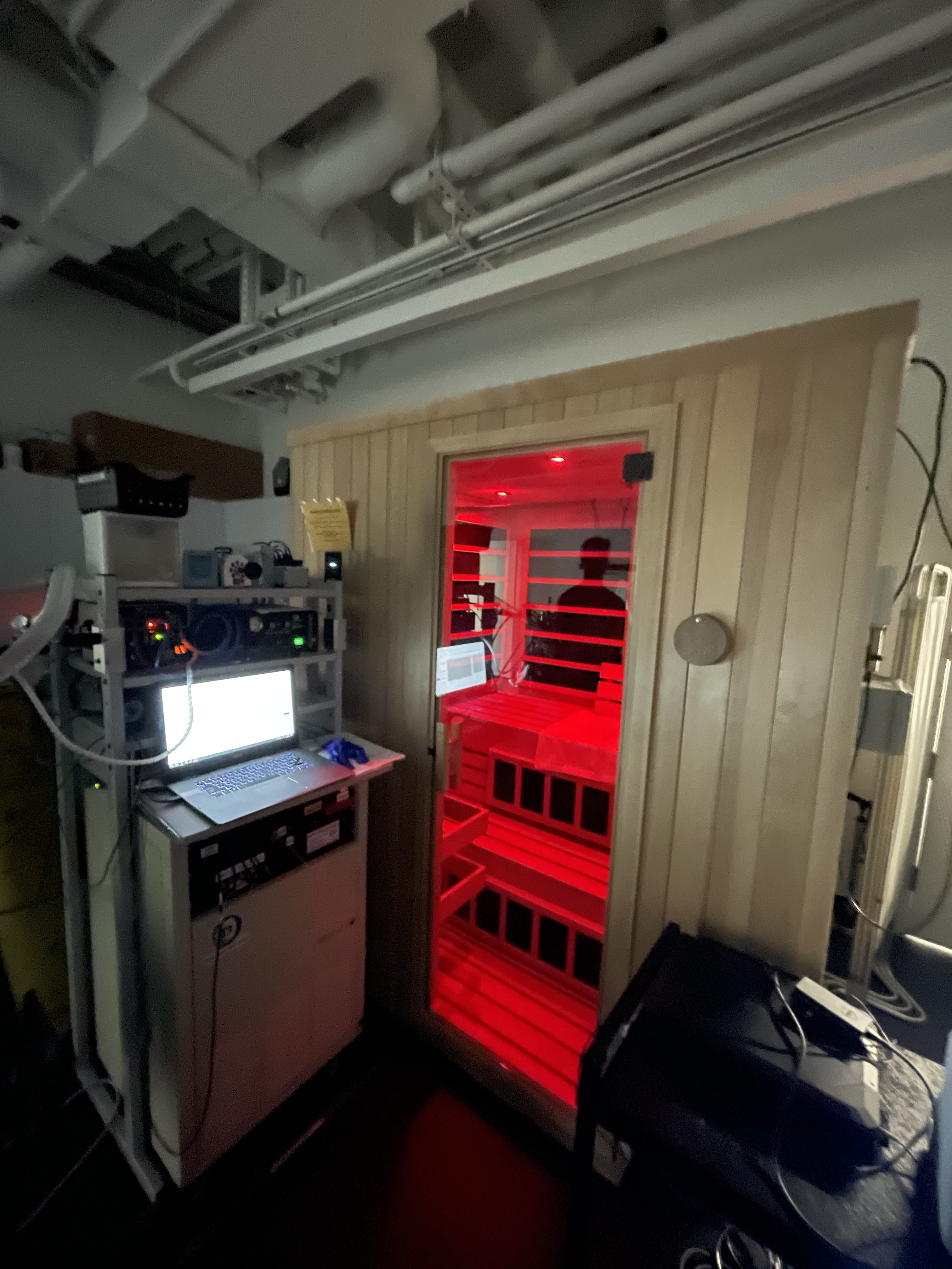 A red glow visible from an infrared sauna in a laboratory setting