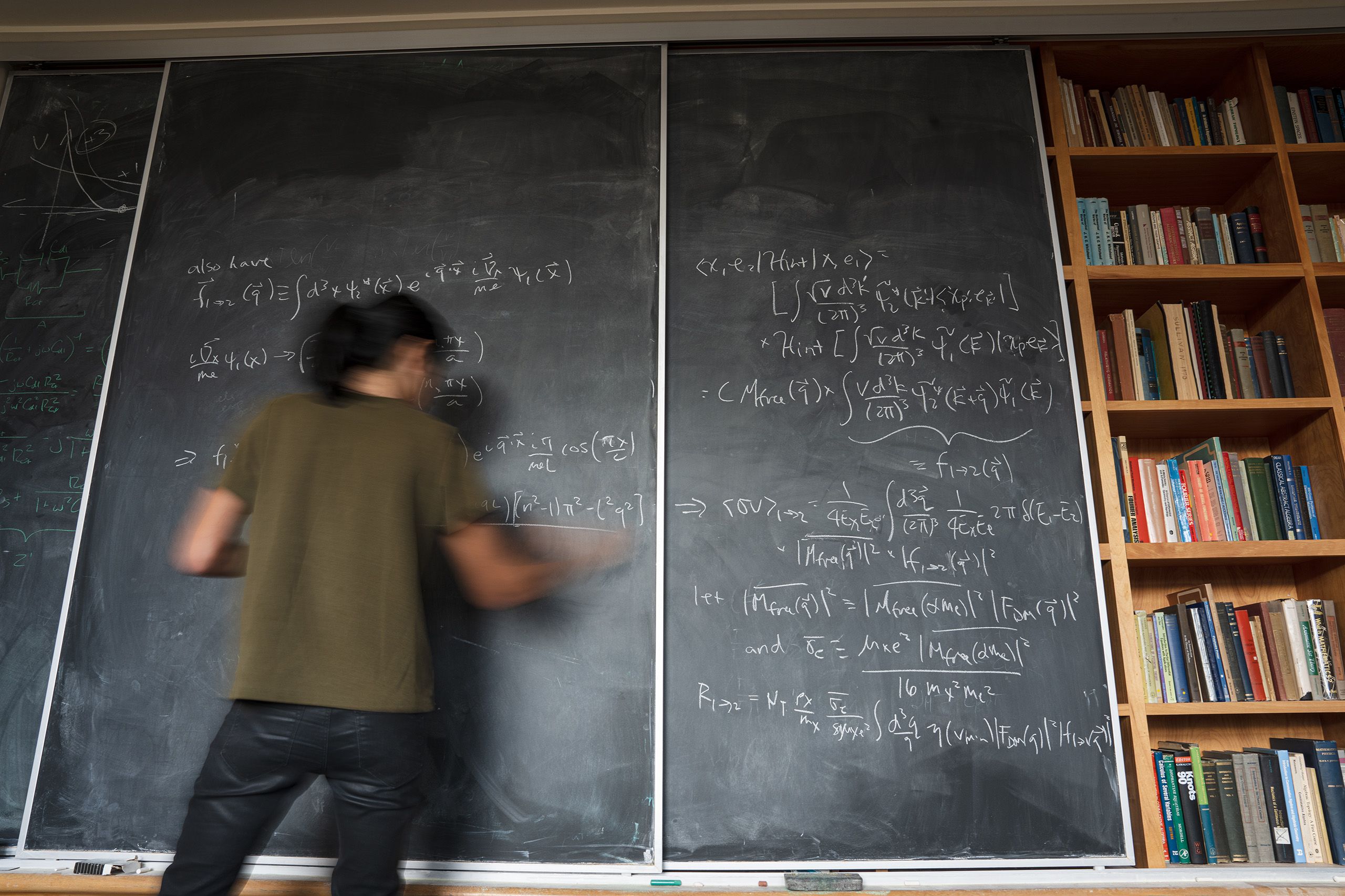 Blurred photo of woman writing on blackboard