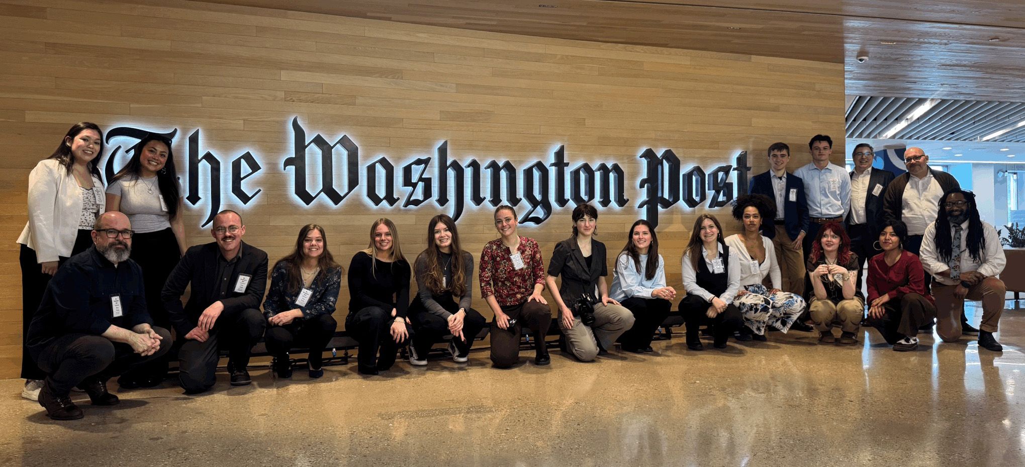 Students posing under the Washington Post sign