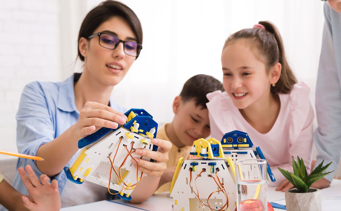 A teacher shows children how to use robotics.