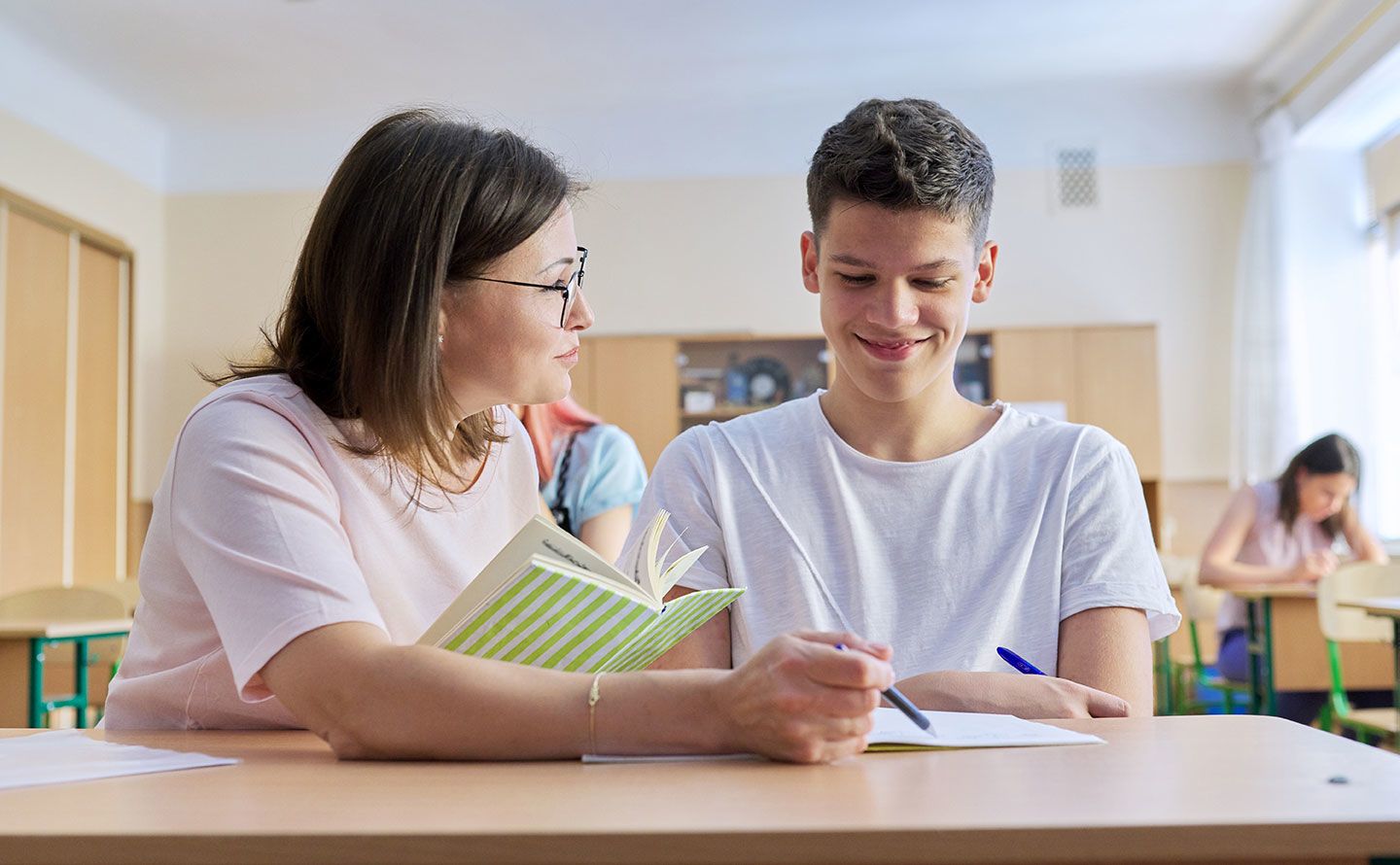 A counselor works with a young man in high school.lt text goes here