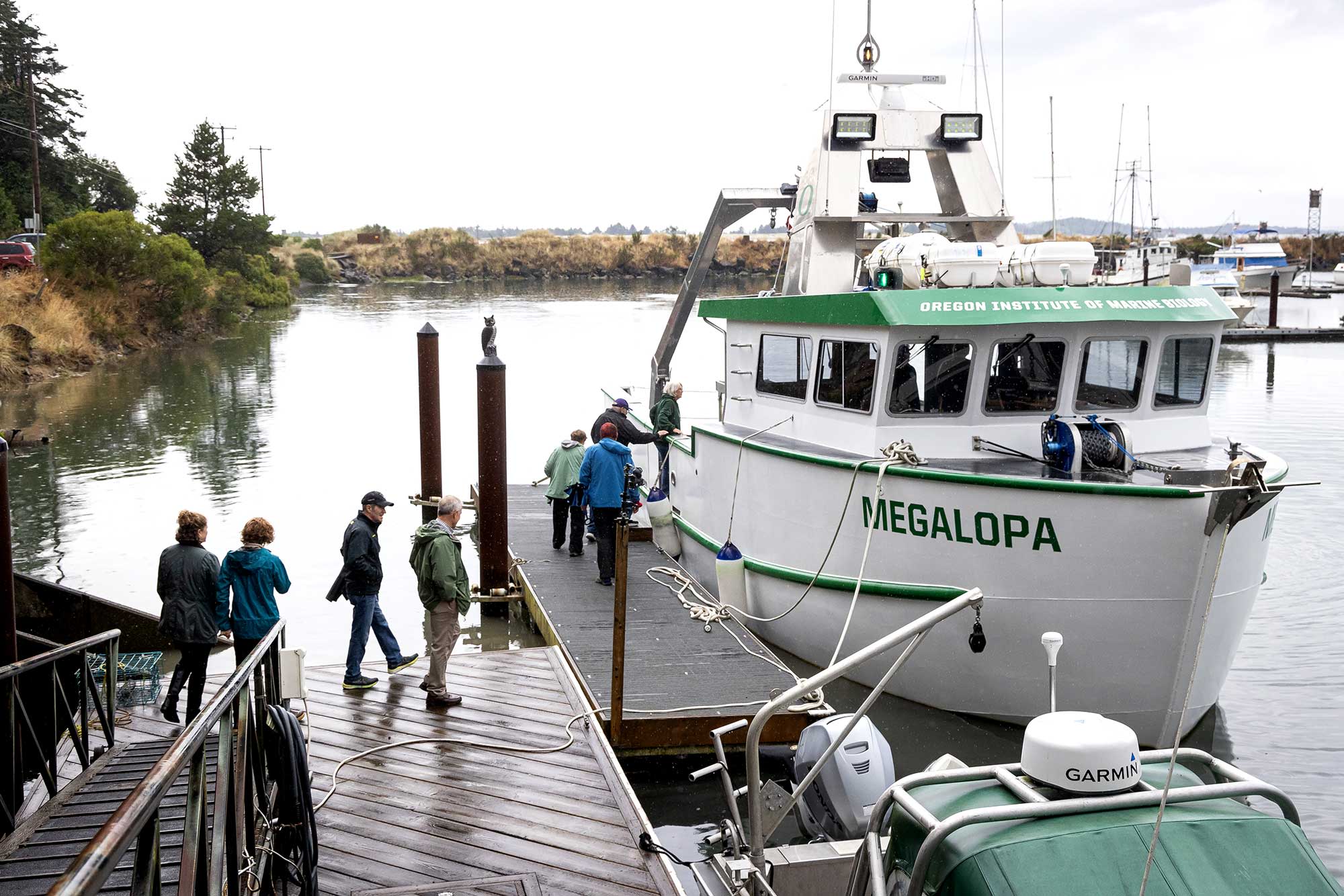 People board a green and white boat named