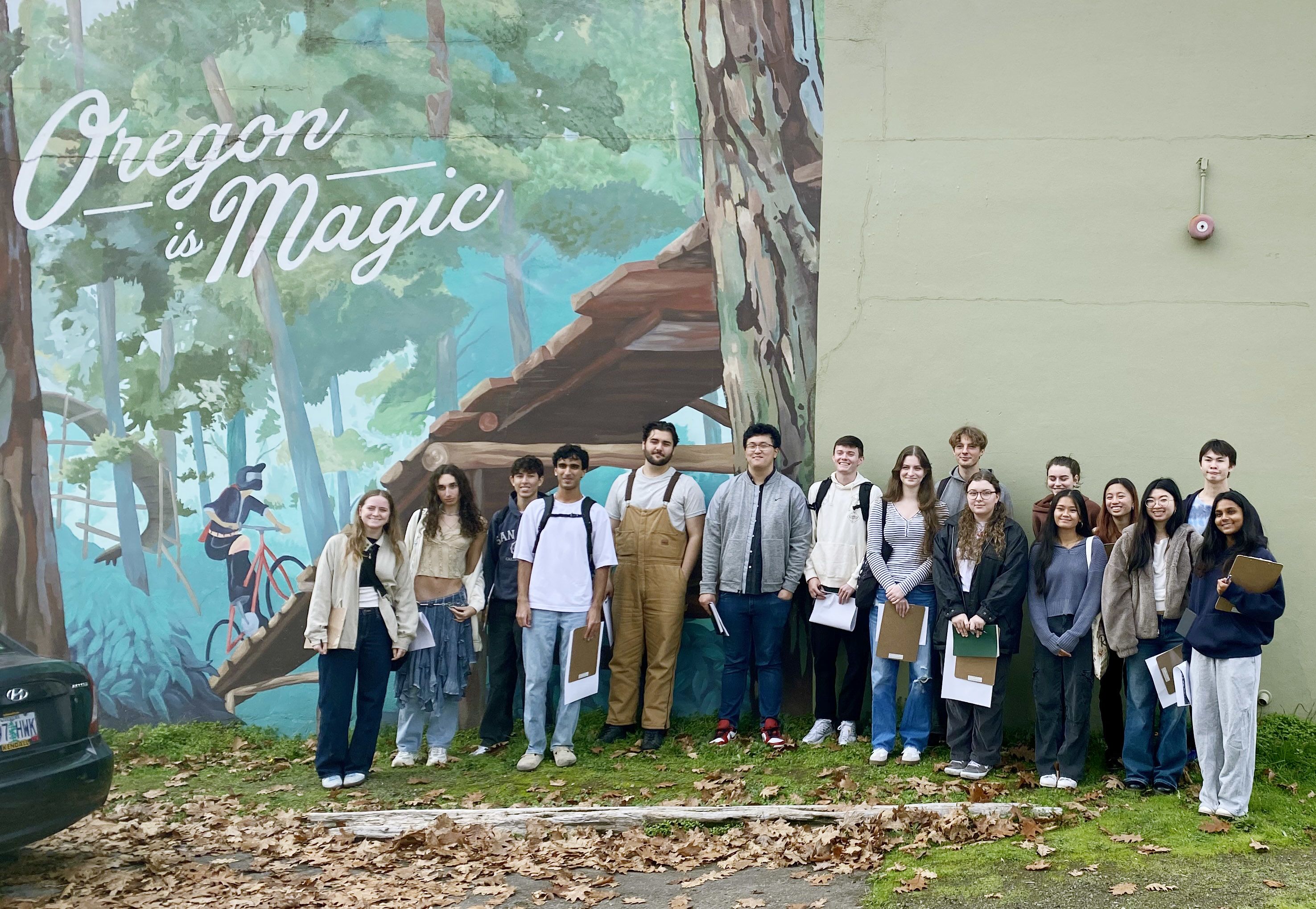 Group of students posing in front of outdoor mural