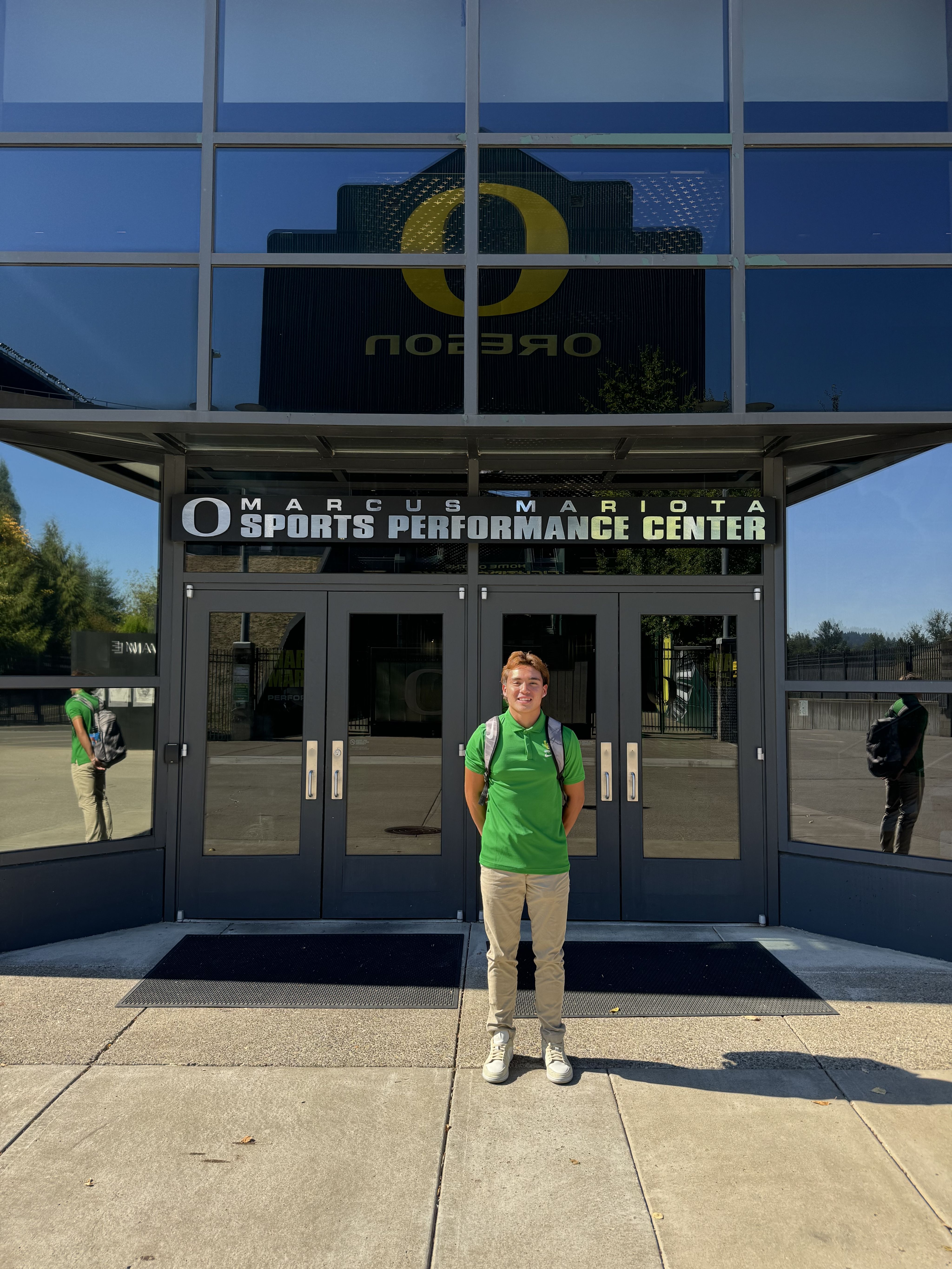 a man wearing a green polo shirt outside a UO building