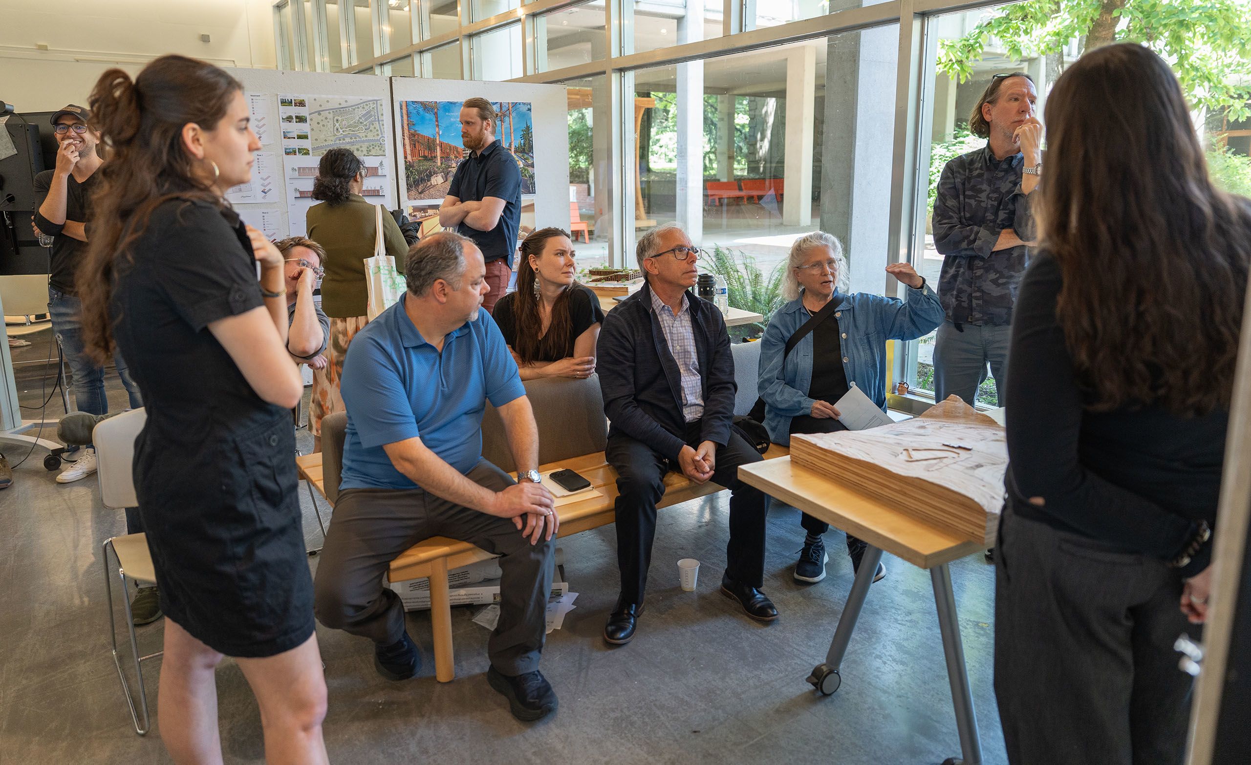 People in a room looking at drawings and plans