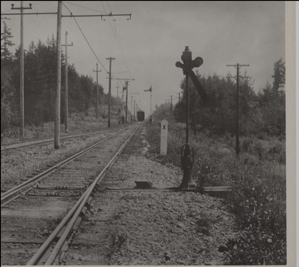 a black and white photo showing a railroad crossing