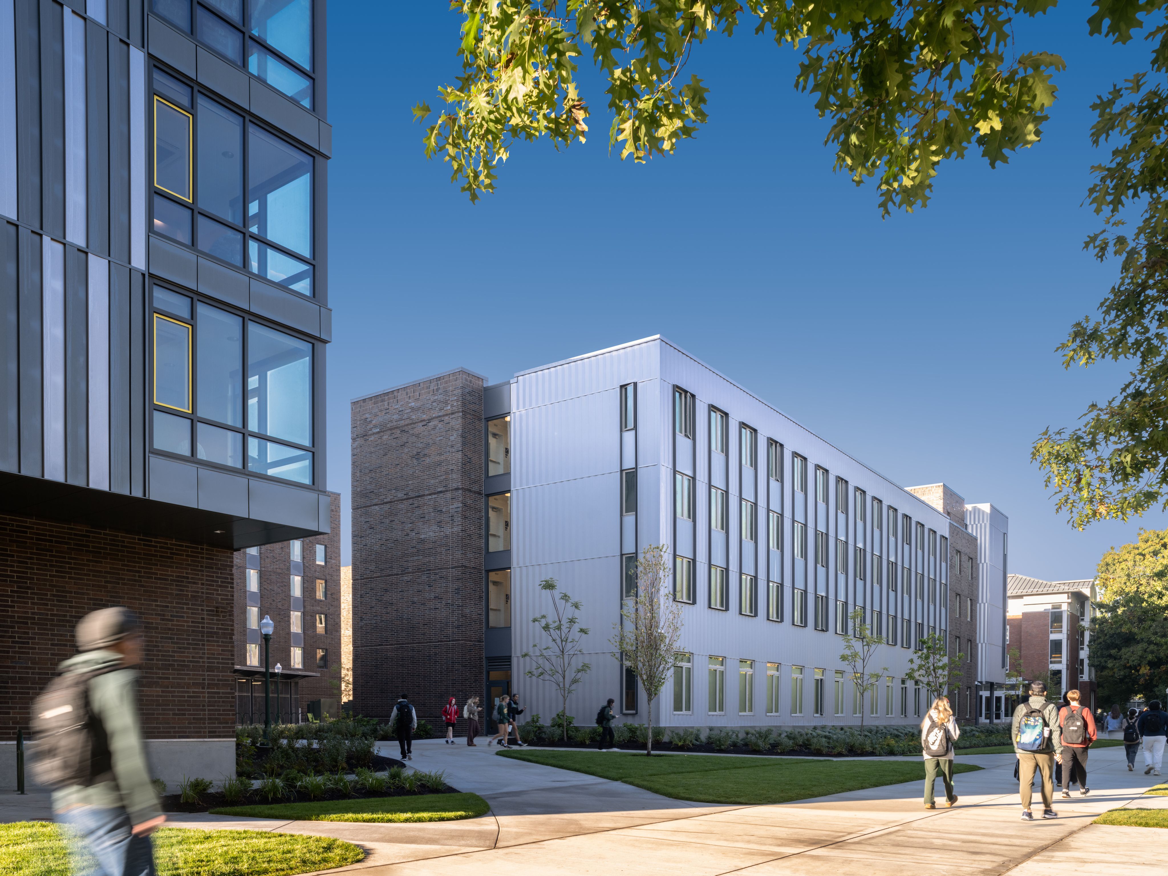 Exterior of Yasui Hall in daytime with students walking by